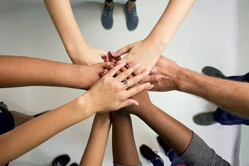 Hands joined together in a gesture of community support